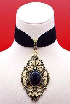 The BAROQUE Black velvet choker necklace featuring large antique gold gothic pendant with a choice of red or black cabochon. Pendant size - 8.5cm height x 4.8cm width Choker width - 2.5cm Choice of choker lengths Extender chain - 5cm long Chokers are handmade to order so if you require any customisation please get in touch. Your order will arrive complete with velvet gift bag. Free UK delivery & combined shipping discounts on international orders! Victorian Choker Necklace, Victorian Choker, Black Velvet Choker Necklace, Gothic Pendant, Velvet Choker Necklaces, Black Velvet Choker, Gothic Victorian, Velvet Choker, Cabochon Pendant