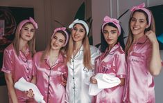 four women in pink pajamas posing for a photo