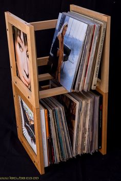 a wooden rack with various records on it's sides and an album holder in the middle