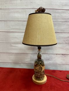 a lamp that is sitting on top of a red table cloth next to a wall