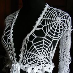 a white crocheted shawl on top of a mannequin's torso