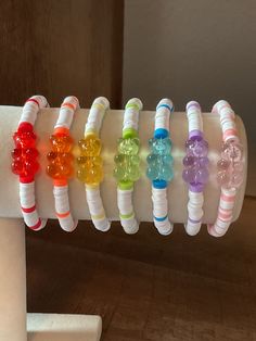 a bunch of bracelets that are sitting on a white tube with some beads attached to it