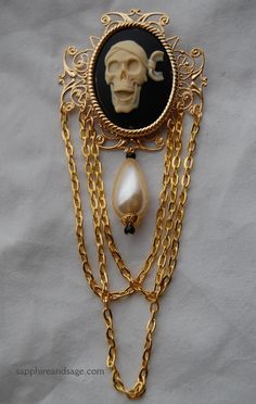 Makes a great addition to a Pirate's jacket, dress bodice, gown , hat, or bag! Large resin cameo on a cluster filigree metal base, measuring roughly 3 inches by 6 inches. *  Who is Sapphire & Sage?   I'm Rhonda, from a small town just West of Akron, Ohio.  Since 2001, I have provided hand-crafted Renaissance and Medieval themed jewelry for my clients all over the world, inspired by historical portraits, as well as beloved sci-fi and fantasy films and TV shows.  I work with faire cast members and Freddie Facilier, Pirate Illustration, Skull Brooch, Portrait Jewelry, Pirate Jewelry, Pirate Jacket, Dress Bodice, Gown Skirt, Pirate Skull