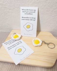 an egg keychain with two eggs on it and a card attached to it