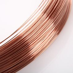 several copper colored wires on a white surface