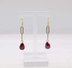 These earrings feature a luxurious gold chain design with a dangling stunning ruby red stone, adding an elegant touch of color and sophistication to any outfit. They're a perfect accessory for adding a touch of glamour to your look. Red Gold Chain Metal Jewelry, Red Metal Jewelry With Gold Chain, Elegant Red Jewelry With Gold Chain, Gold Ruby Drop Earrings, Gold Chain Earrings, Gold Chain Design, Chain Design, Dangling Earrings, Red Stone