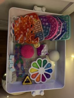 there are many different items in the bins on this shelf, including toys and beads