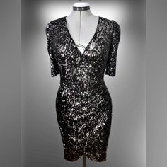 This Is A Brand New With Tags, Calvin Klein Sequined Evening/Party/Special Occasion Dress. The Bodice Crosses Overright Over Leftculminating At The Left Side In Gathers Which Fall Back Into Soft Folds Of A Left To Right Tulip Hem. The Sequins Are Sewn On To A Black Fabric. The Sequins Are Of A Metallic Gunmetal Color On One Side, And A Silvery Metallic Color On The Reverse. Ladies Size 10. Fitted V-neck Sequin Dress For Festive Occasions, Silver Fitted V-neck Evening Dress, Fitted Shimmer Dress For Festive Season, Festive V-neck Evening Dress For Night Out, Shimmer Dresses For Party Season, Shimmer Dress For Festive Occasions, Shimmer Dresses For Festive Party Season, Fitted Metallic Sequin Dress With V-neck, Silver V-neck Sequin Party Dress