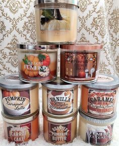 six candles are stacked on top of each other in tins, with pumpkin designs