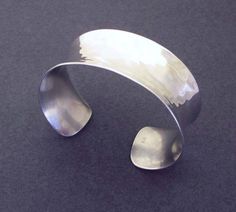 This cuff bracelet is handcrafted in sterling silver 925, hammered and contoured into sensual curves, then brush polished to a shiny finish with subtle brushstrokes visible. The result is a stylistic mix of ancient and modern, chunky and sleek. Classic and elegant in its simplicity, this cuff bracelet is so versatile, it can be worn with a variety of outfits, and from day to evening. Band width is 1 inch (2.5cm). Cuff is slightly flexible for size adjustment. Select your size: SMALL - for a wris Chunky Silver Jewellery, Silversmithing Jewelry, Hammered Cuff Bracelet, Hammered Bracelet, Cuff Bracelets Handmade, Gold Bracelet Cuff, Handmade Modern, Sterling Silver Cuff Bracelet, Sterling Silver Cuff