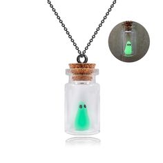 a glass bottle with a green glow in it and a black chain hanging from the front