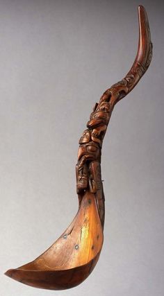 an old wooden spoon with carved carvings on it's side and in the shape of a bird