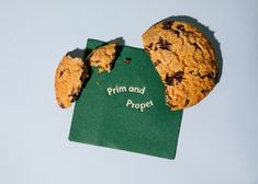 two chocolate chip cookies with the word prima and proper written in green paper next to them