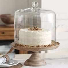 a cake under a glass dome on a table