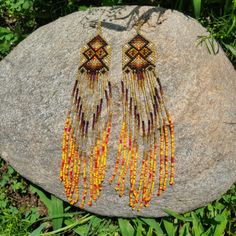 These stunning and sparkling Yawanawa earrings come from Aldeia Yawarany in Acre, Brazil. The Yawanawa are revered for their gorgeous beadwork and earrings. These items have been collected from the daughter of the Cacique, and the women of the village to raise money for the recent floods in Tarauaca. All earrings are one of a kind, hand made and take months to create. Product Description: 1.25'' width and 8'' inch dangling drop with ombre beads and sacred kene design. Jewellery Shoot, Beaded Earrings Native, Ankle Jewelry, Beaded Earring, Light Earrings, Earring Ideas, Beading Tutorial, Golden Light, Earring Tutorial