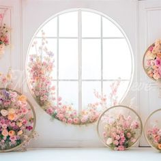 several vases with flowers in front of a round window