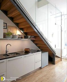 a kitchen area with sink, counter and stairs