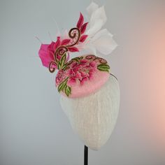 THIS ONE IS MADE TO ORDER IN YOUR CHOICE OF COLORS FOR BASE AND FEATHERS, EMBROIDERED PART WILL BE THE SAME COLOR ☀ Follow this link for more beautiful choices from 'Indigo Hats'  https://www.etsy.com/shop/IndigoHats ☀ I love the drama of this hat!  I handblocked layers of light pink straw in a flattering button shape.  Then added a stunning embroidered floral lace design in pink and gold with a lively flourish to follow the lines of the hat.   Matching hand tied exuberant ombre feathers  around Handmade Fitted Hats For Formal Occasions, Handmade Fitted Formal Hats, Formal Fitted Handmade Hats, Spring Party Sinamay Headpiece, Spring Party Headpieces In Sinamay, Fitted Fascinator With Structured Crown For Events, Fitted Handmade Flower Headpieces For Party, Fitted Evening Fascinator With Handmade Flowers, Handmade Flowers Fitted Headpieces For Party