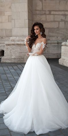 a woman in a white wedding dress standing outside