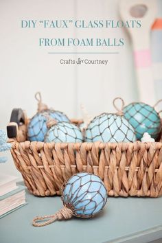 a basket filled with blue glass floats sitting on top of a table next to books