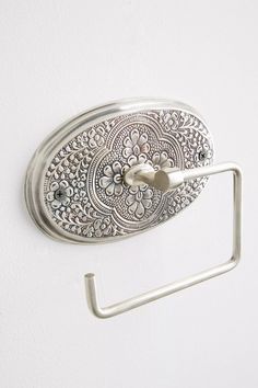 an ornately designed metal hook on a white wall