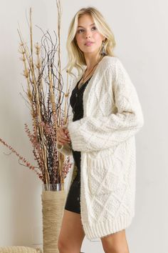 This is it! The softest chunky knit cardigan you will find! Beautiful shade of ivory, cable knit diamond pattern on front, along with pockets. Dress it up, wear over a blouse and pants, or casual with graphic tee and jeans! 32" in length approx. avail in S/M or M/L. 100% polyester *color may vary slightly due to image and screen lighting* **FREE SHIPPING** *In stock ships next business day* Cream Cable Knit Sweater Coat For Fall, Cozy Cream Cable Knit Outerwear, Cream Cable Knit Sweater Coat, Winter White Cable Knit Cardigan For Fall, Cozy Textured Knit Cream Outerwear, Cozy Cream Textured Knit Cardigan, Fall Cable Knit Cardigan In Winter White, Cozy White Cable Knit Cardigan, Cozy Open Knit Cream Cardigan