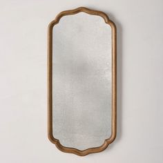 a wooden mirror hanging on the wall