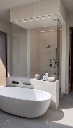 a large white bathtub sitting in the middle of a bathroom next to a walk in shower