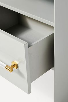 a white cabinet with gold handles and drawers