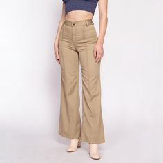 Vintage 70s women's khaki high waist trousers with a flared leg, brown contrast stitching and pleating down the fronts of the legs, and a saddleback cut in the back. They have been taken in about 1/2" at each side of waist, which could be let out if desired. Measurements and Condition: Fits like: Small (see measurements to ensure fit) Fabric: Feels like polyester Brand: March Condition: Very good, with light general wear, and two tiny brown spots on the inner left leg. Waist: 25.5" Hips: 37" - taken at the bottom of the zipper opening Rise: 11.25"  Inseam: 31" Shown on a 5'8" model with measurements of 34"-26"-37", usually wears a size small. See our FAQ for more info on sizing and condition ratings. Khaki Fitted Full-length Bottoms, Fitted Full-length Khaki Bottoms, Fitted Full Length Khaki Bottoms, Fitted High Waist Khaki Pants, Khaki Slim Fit High Waist Pants, Fitted Wide Leg Khaki Bottoms, Fitted High Waist Wide Leg Khaki Pants, Khaki Fitted Wide-leg Pants, Fitted Khaki High-waisted Pants