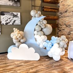 balloons are arranged in the shape of an moon and clouds on display at a party