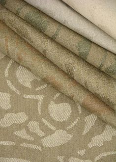 four different colored fabrics are stacked on top of each other, one is white and the other is beige