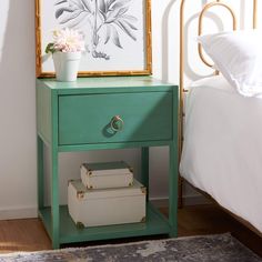 a green nightstand with flowers on it next to a bed and a framed print in the corner