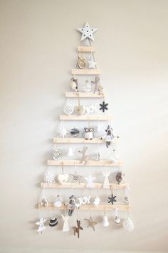 a christmas tree made out of wooden pallets with ornaments hanging from the top and bottom