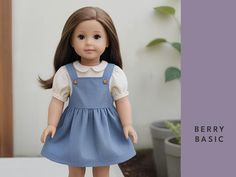 the doll is wearing a blue dress and white shirt