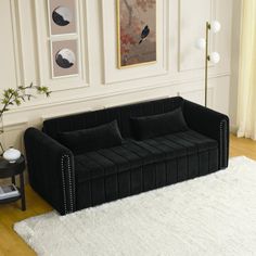 a black couch sitting on top of a white rug