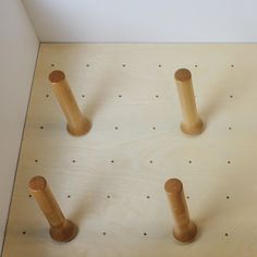 four wooden pegs are arranged on a board