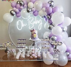 a baby shower is set up with balloons and cupcakes for the baby to eat