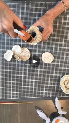 someone is making some paper flowers out of twine and other crafting supplies on a table