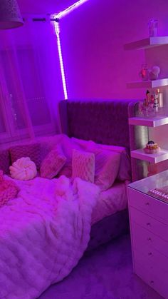 a bedroom with purple lighting and pink bedding