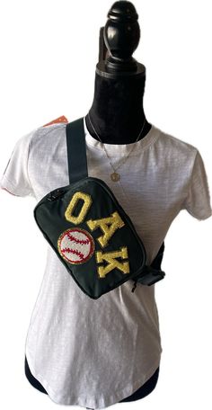 Oakland Athletics, Oakland As Baseball Inspired Cross Body Bag/Belt Bag/Shoulder Bag. Stadium Approved Size Our Spirit Bag has a multi use strap with buckle closure allowing the bag to be used as a crossbody, fanny pack or shoulder bag. It is roomy for its compact size with a zipped pocket on the back and mesh pockets on both sides inside; one full pocket on one side and two smaller pockets on the other side. Each bag is crafted from lightweight nylon that makes it both waterproof and easy to cl Travel Crossbody Bag With Embroidered Logo, Trendy Shoulder Bag With Embroidered Logo For Travel, Travel Crossbody Shoulder Bag With Embroidered Logo, Trendy Everyday Bag With Letter Patch, Spirit Bags, Crossbody Fanny Pack, Bag Belt, Oakland Athletics, Bag Shoulder