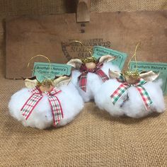 two small angel ornaments on top of fluffy white balls