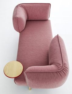 an upholstered pink chair with a wooden table on the bottom and back end