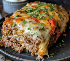 a close up of a slice of lasagna on a plate with green garnish