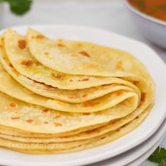 a white plate topped with tortillas on top of a table