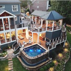 an aerial view of a house with a pool in the yard and decking area