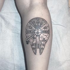 a tattoo on the leg of a person with a star wars millennium wheel in it