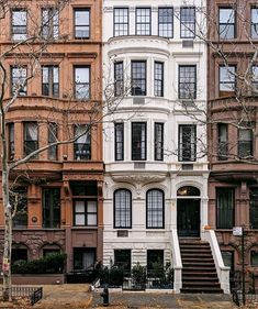 an apartment building with many windows and steps leading up to the front door, in new york city