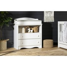 a white crib and dresser in a room