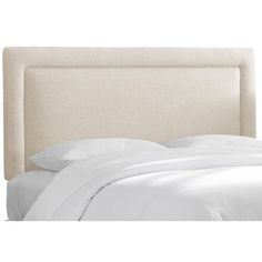 an upholstered headboard with white sheets and pillows